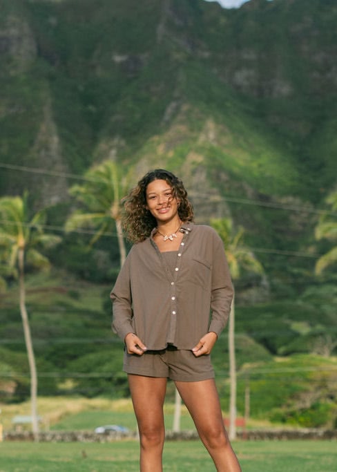 Woman wearing loose button up, smocked tube top and short in medium brown linen.