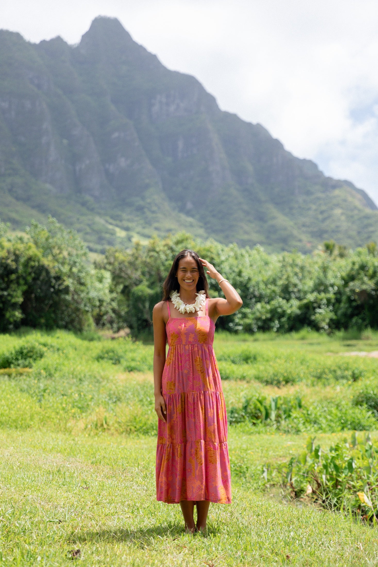 woman wearing a pink tie back maxi dress with lei print