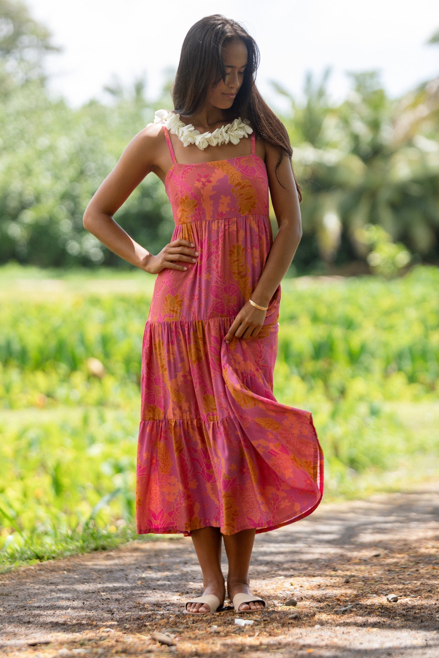 woman wearing a pink tie back maxi dress with lei print