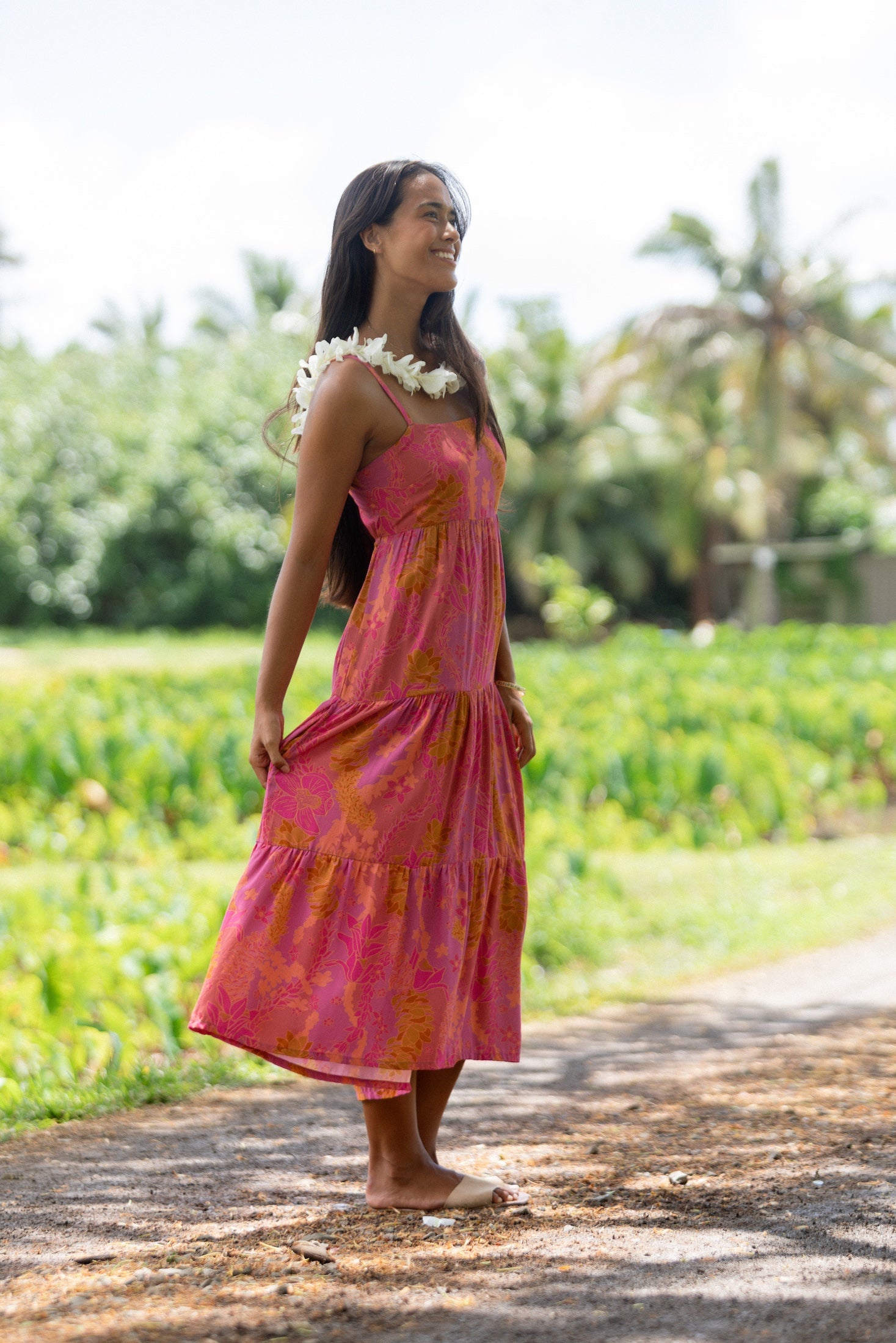 woman wearing a pink tie back maxi dress with lei print