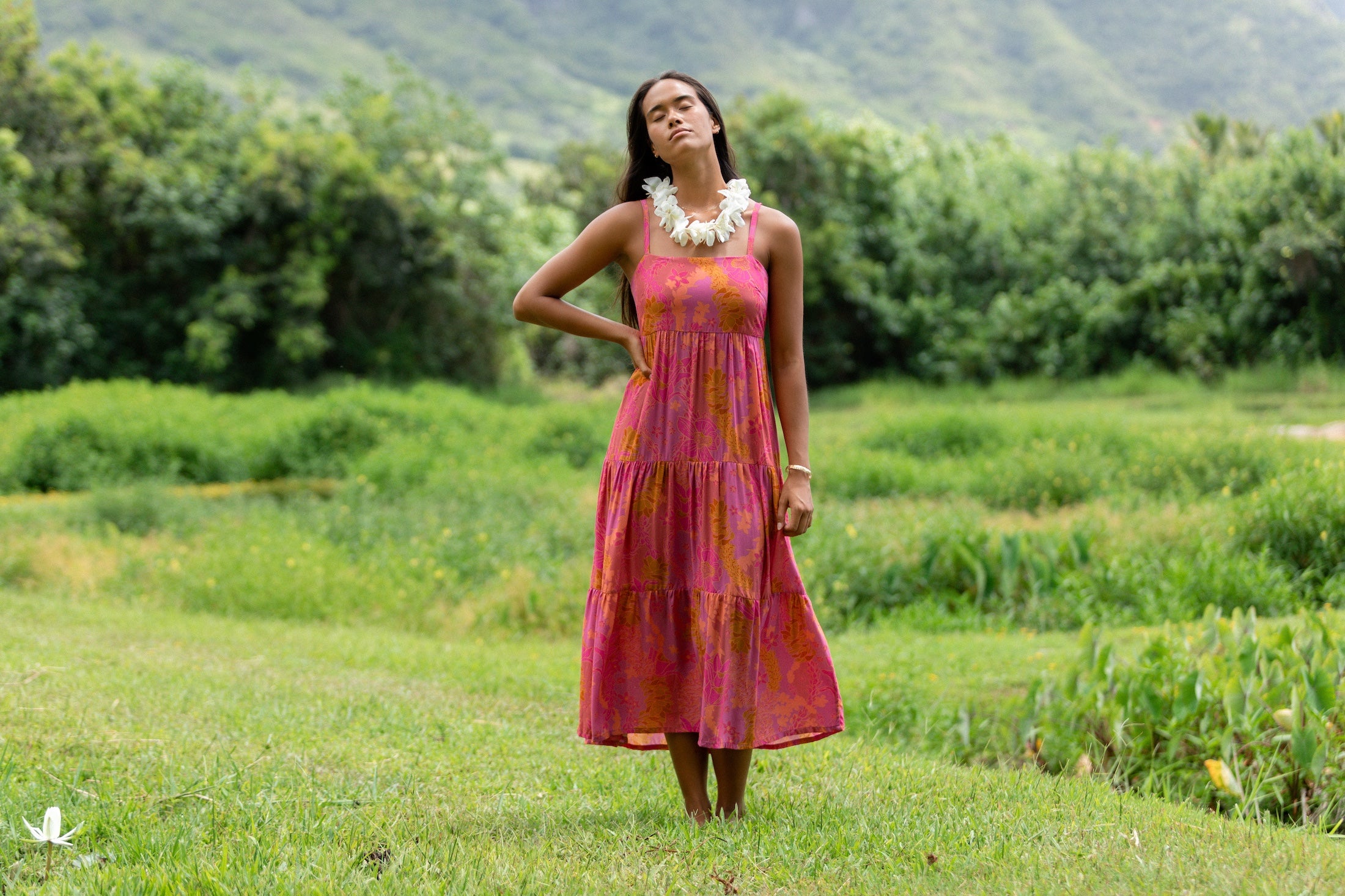 woman wearing a pink tie back maxi dress with lei print