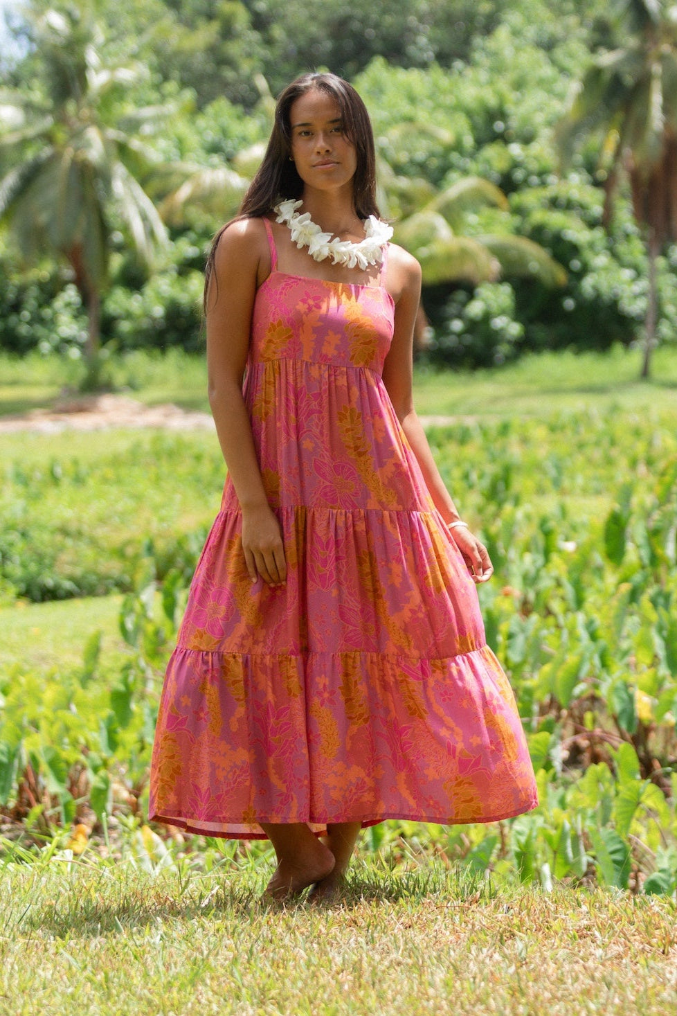 woman wearing a pink tie back maxi dress with lei print