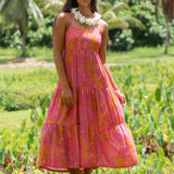 woman wearing a pink tie back maxi dress with lei print