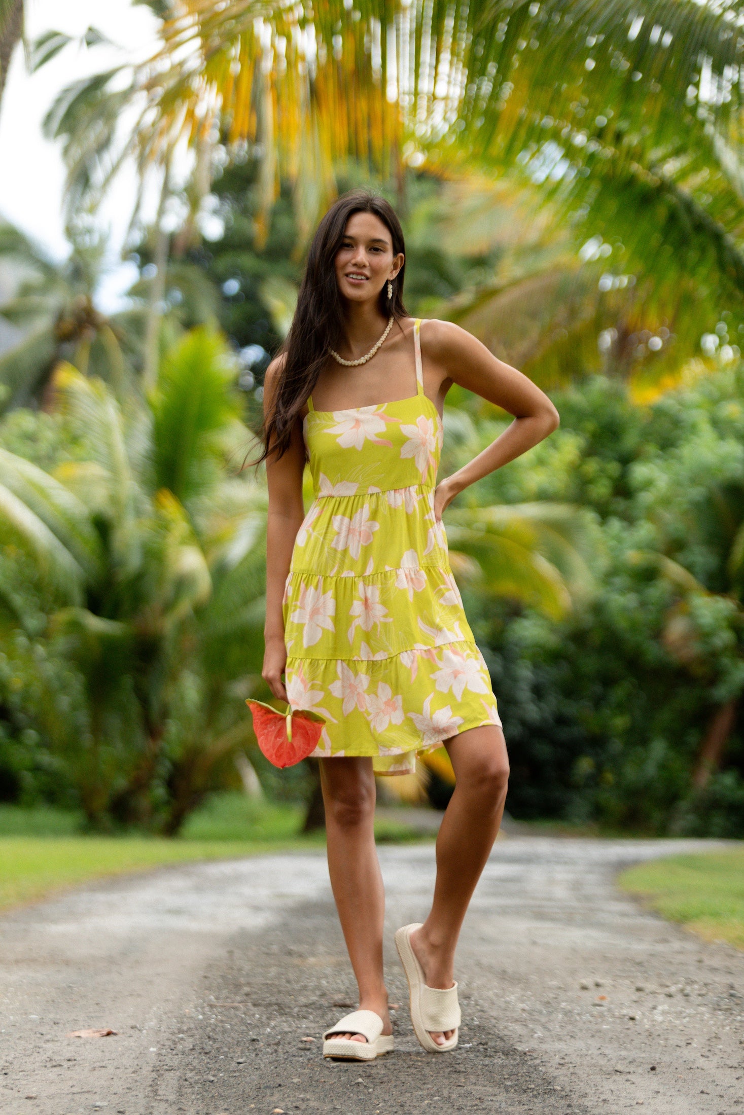 woman wearing a bright green tie back mini dress with orchid print