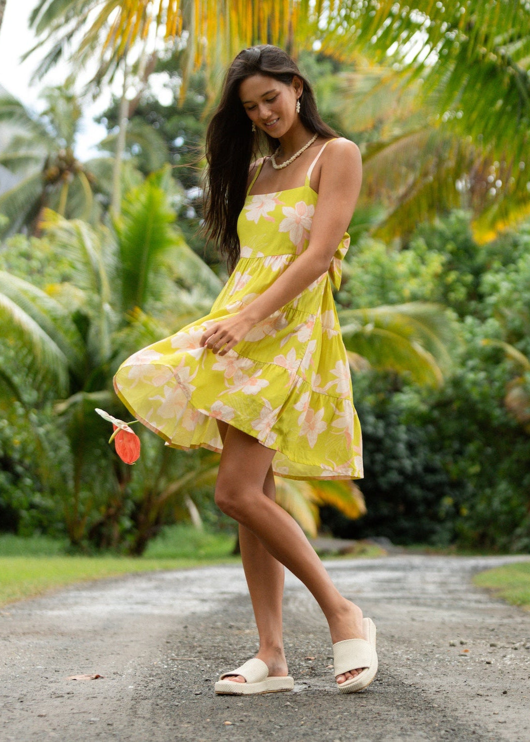 woman wearing a bright green tie back mini dress with orchid print