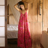 A woman with dark hair wears a YIREH v-neck, wide legged jumpsuit. It is the Laney Jumpsuit in the Garden 'Awapuhi print.
