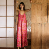A woman with dark hair wears a YIREH v-neck, wide legged jumpsuit. It is the Laney Jumpsuit in the Garden 'Awapuhi print.