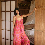 A woman with dark hair wears a YIREH v-neck, wide legged jumpsuit. It is the Laney Jumpsuit in the Garden 'Awapuhi print.