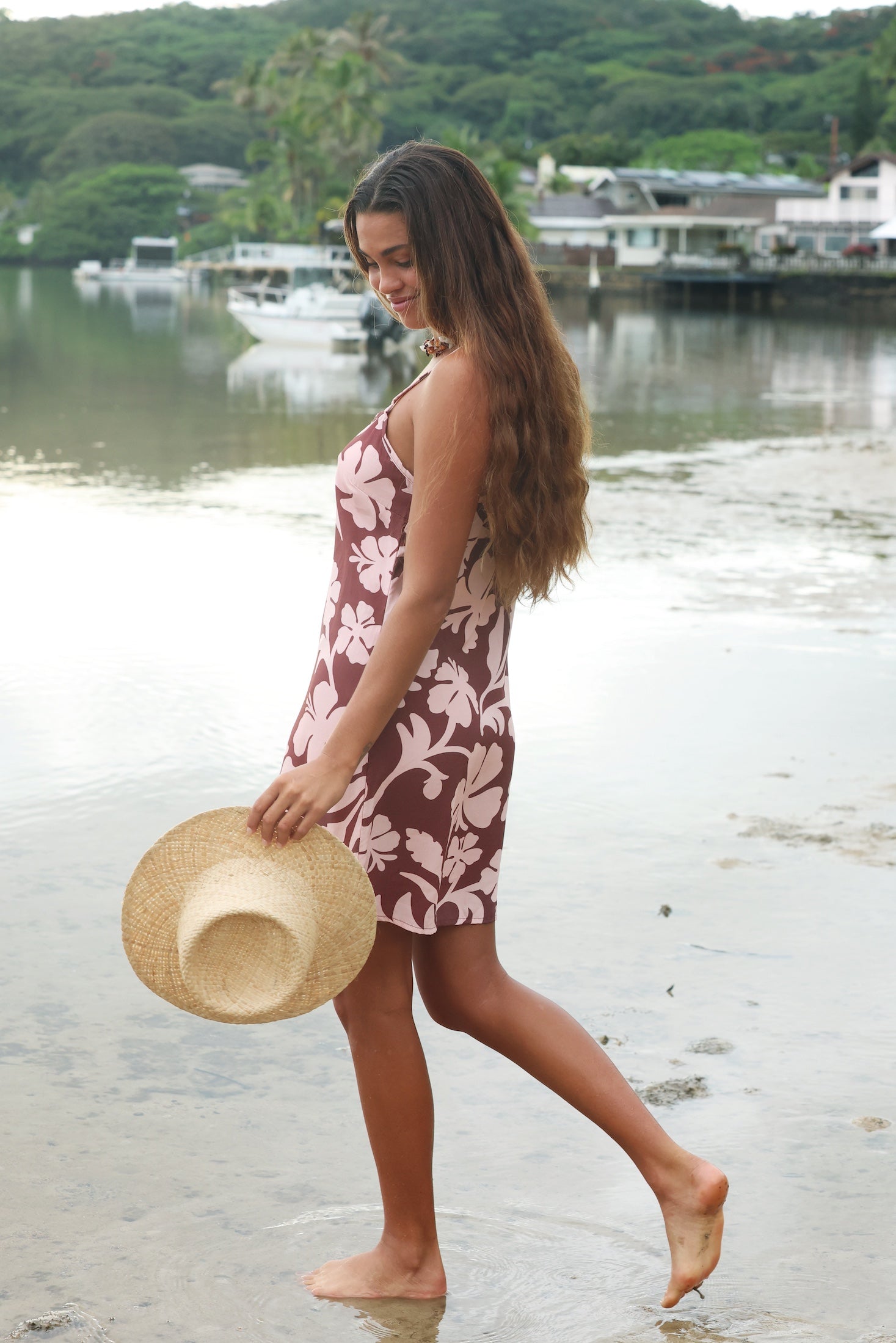 Woman with brown hair wearing a simple slip dress with scoop neck in blush and brown hibiscus print