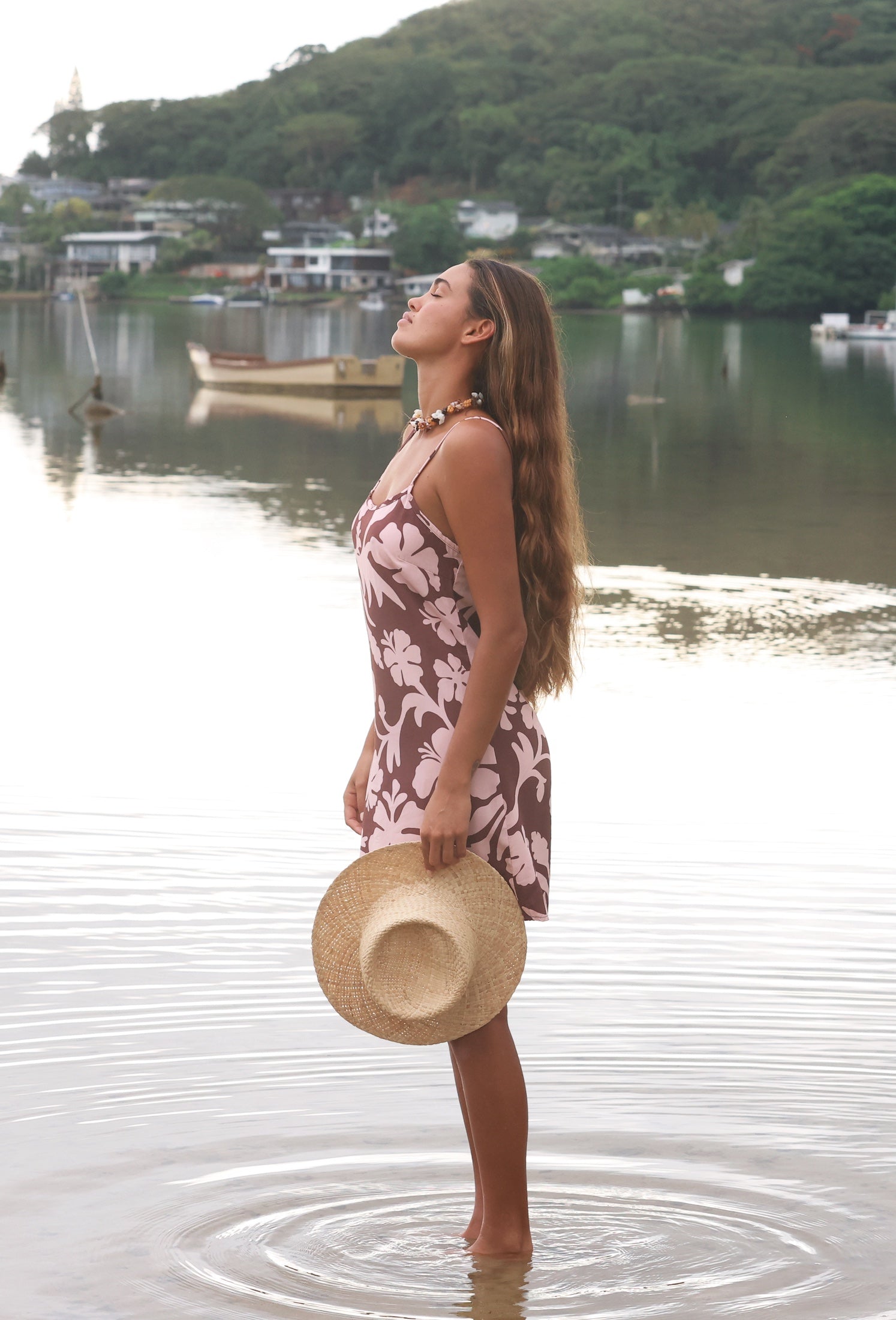 Woman with brown hair wearing a simple slip dress with scoop neck in blush and brown hibiscus print