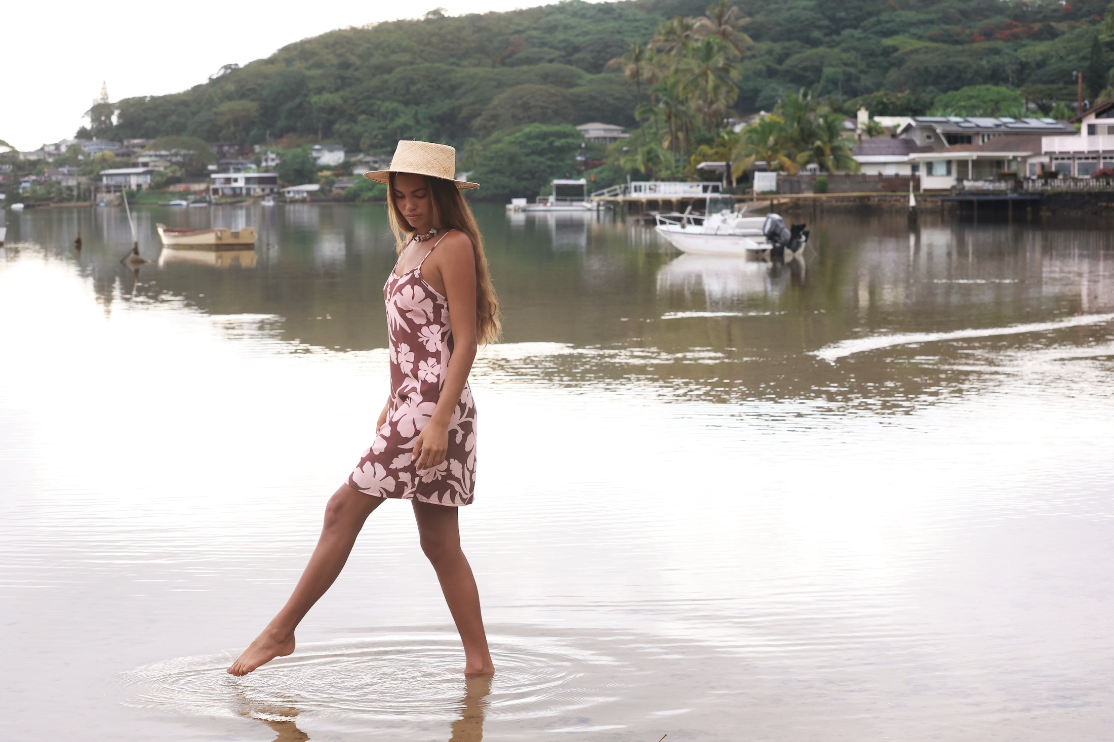 Woman with brown hair wearing a simple slip dress with scoop neck in blush and brown hibiscus print