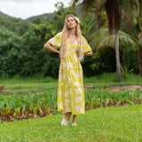 woman wearing a bright green v neck maxi dress with flutter sleeves with orchid print