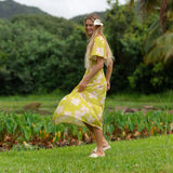 woman wearing a bright green v neck maxi dress with flutter sleeves with orchid print