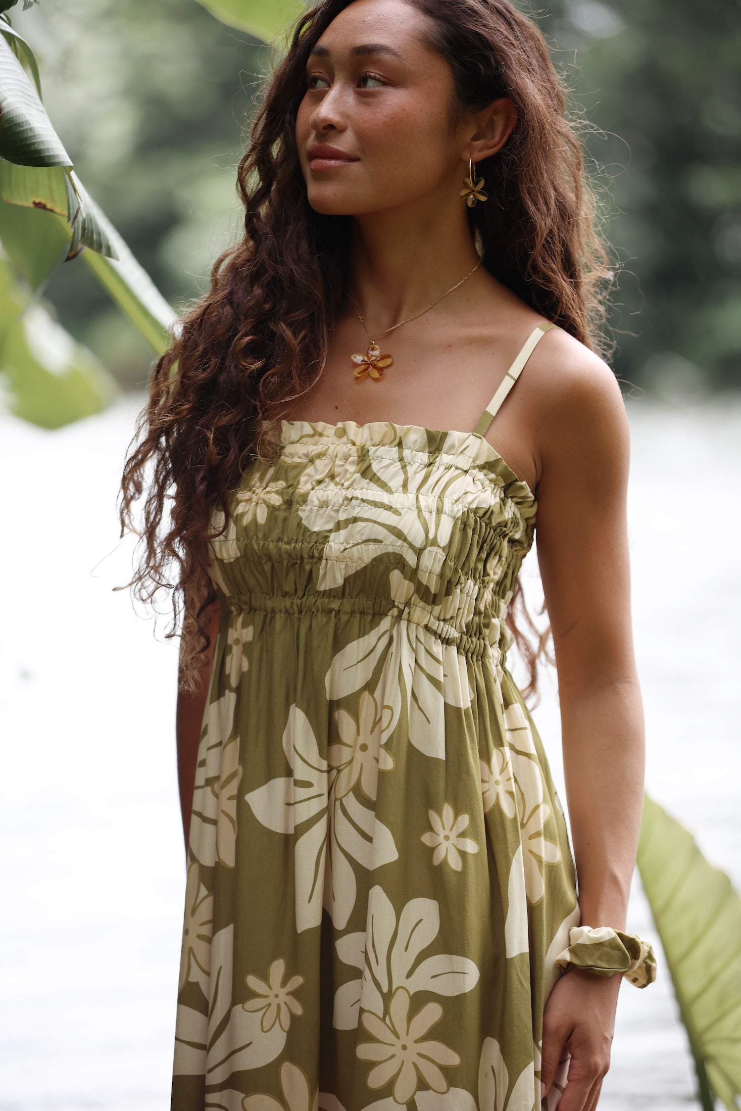 woman with brown hair wearing yellow glass plumeria necklace and earrings