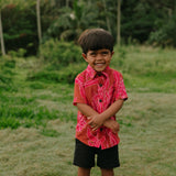 Boy in brown button up shirt with large pink floral print