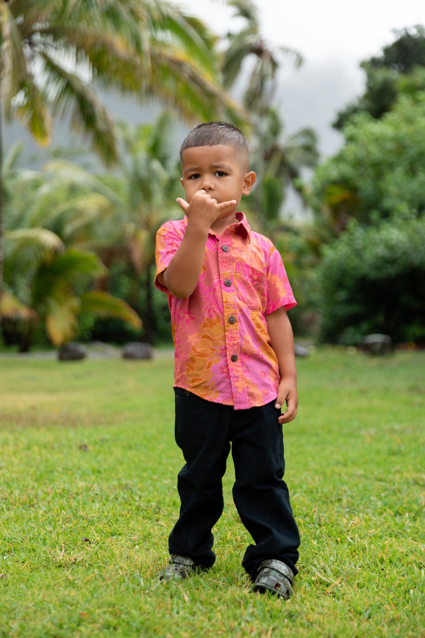 little boy wearing a mini aloha button up shirt in pink with lei pattern