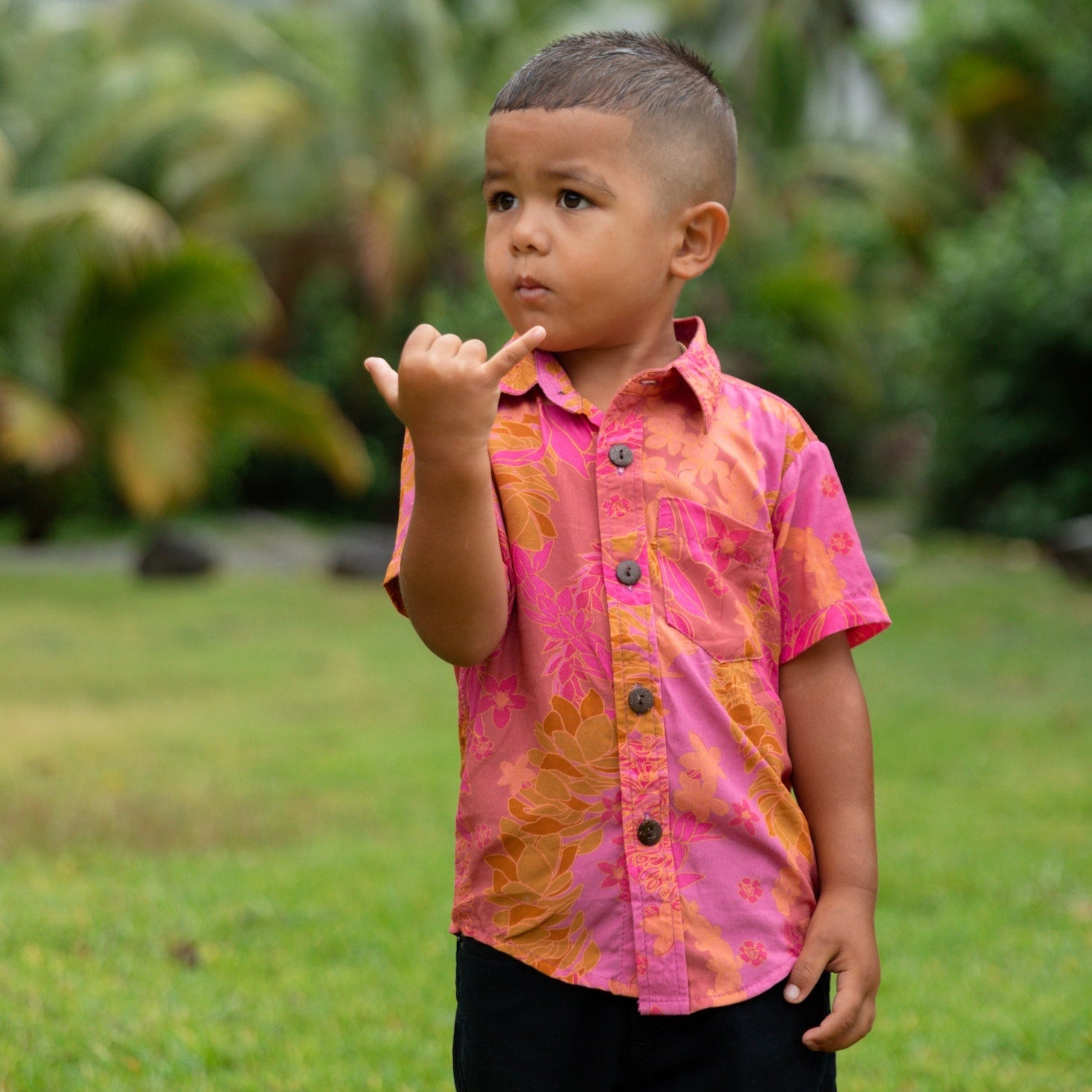 little boy wearing a mini aloha button up shirt in pink with lei pattern