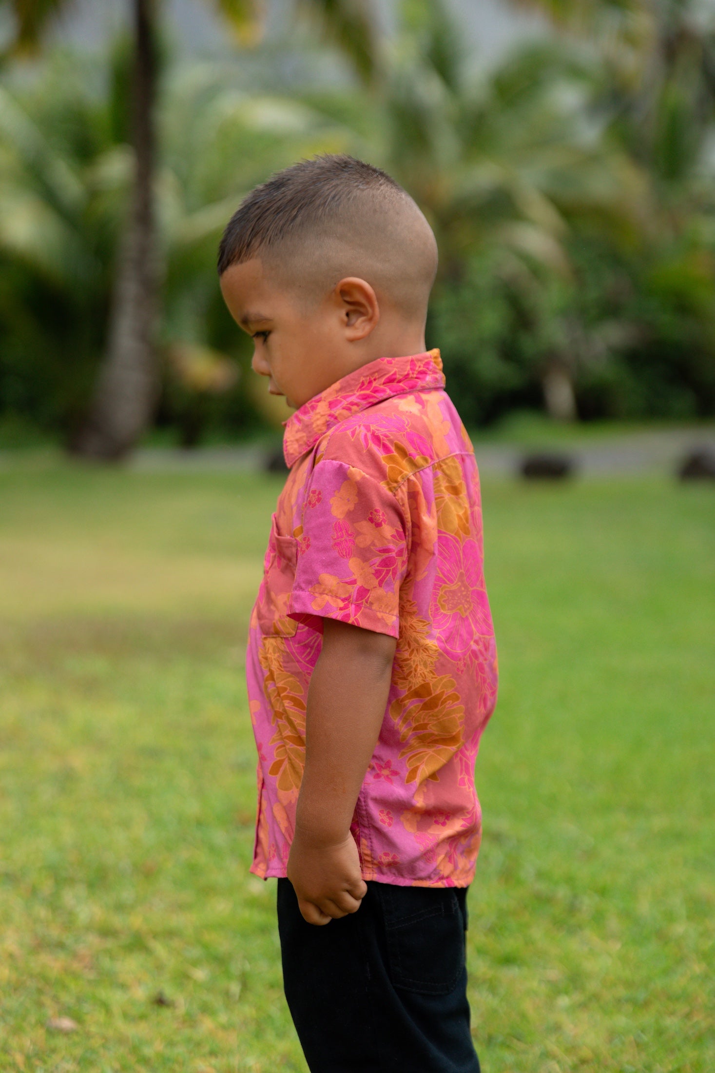 little boy wearing a mini aloha button up shirt in pink with lei pattern
