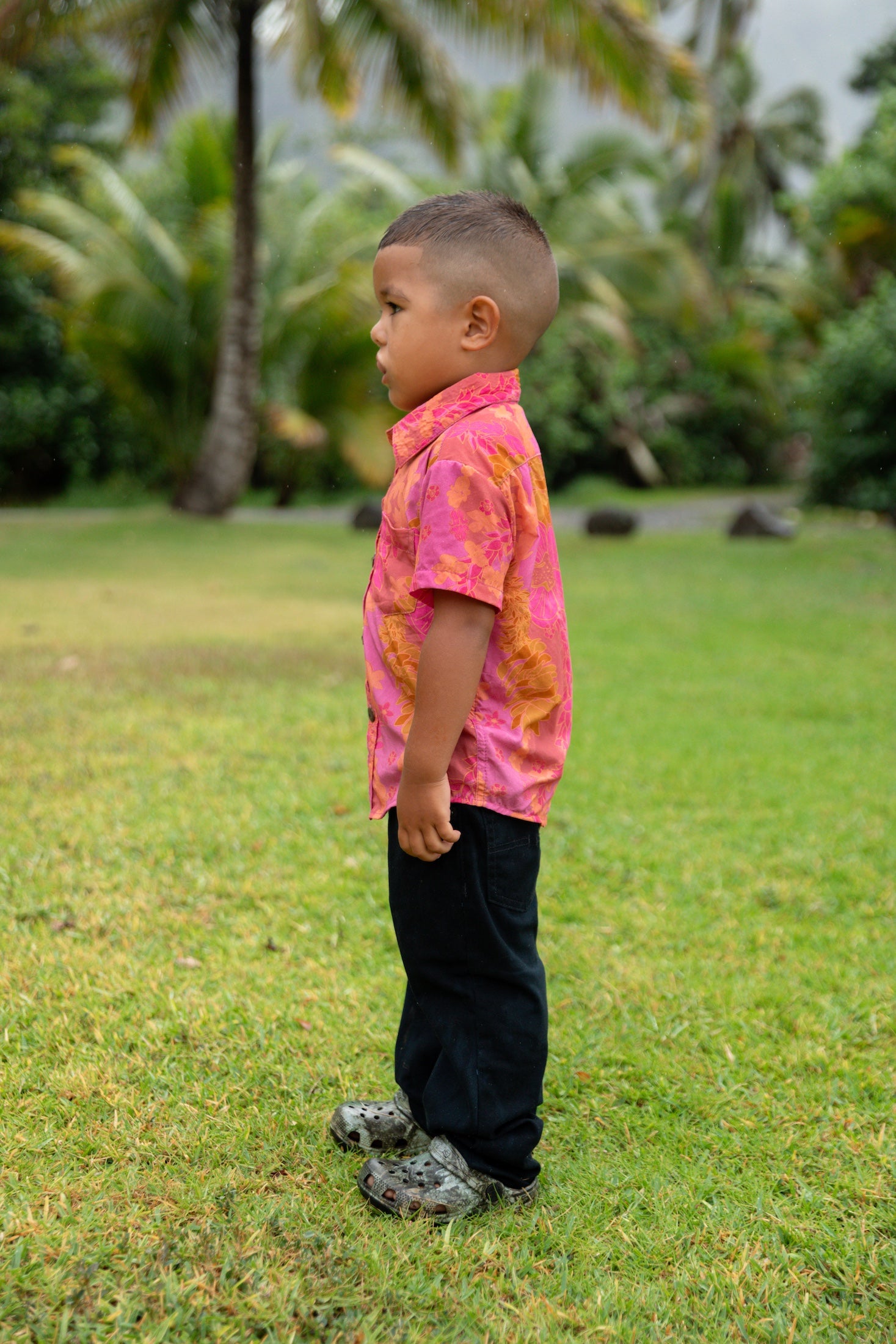 little boy wearing a mini aloha button up shirt in pink with lei pattern
