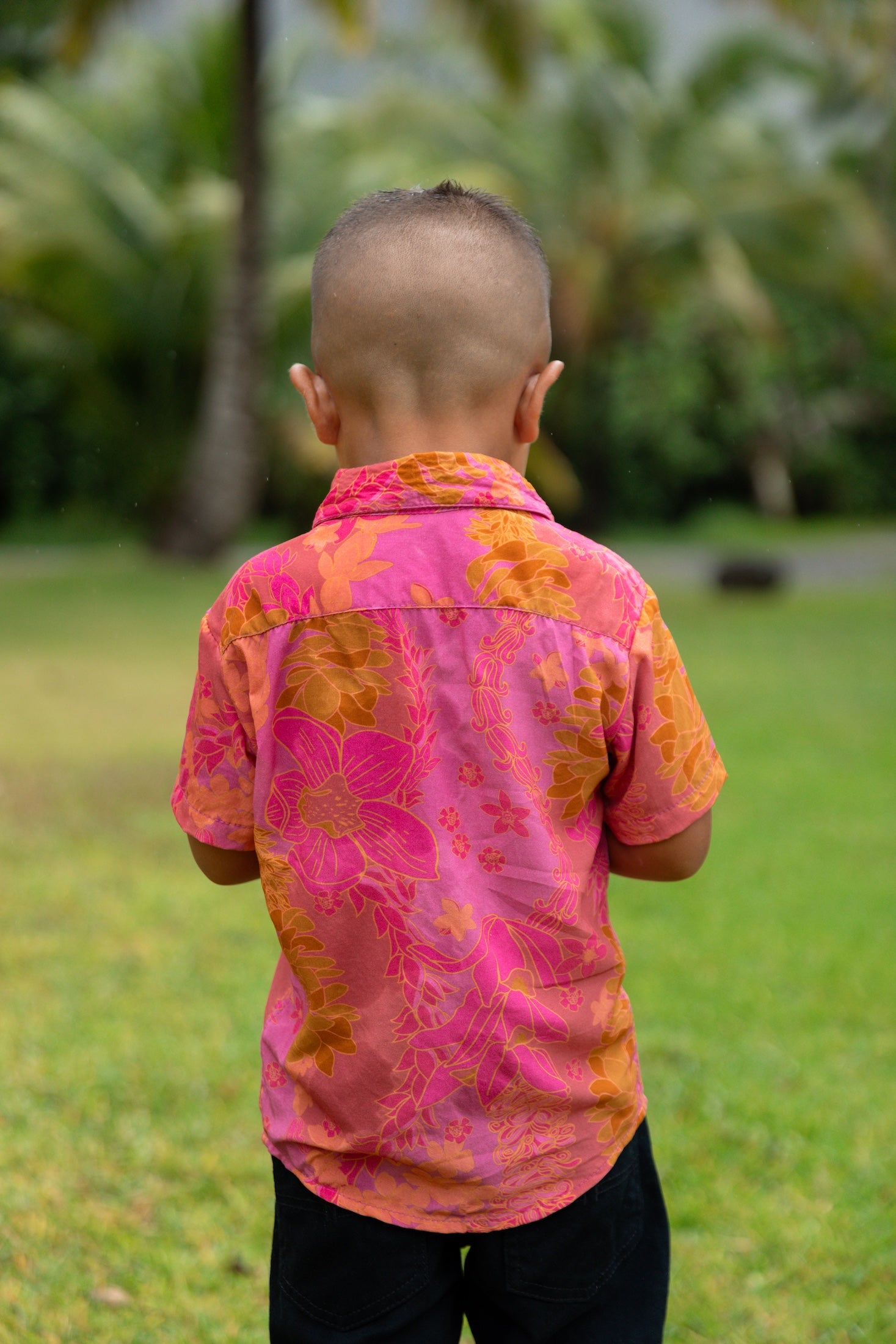 little boy wearing a mini aloha button up shirt in pink with lei pattern