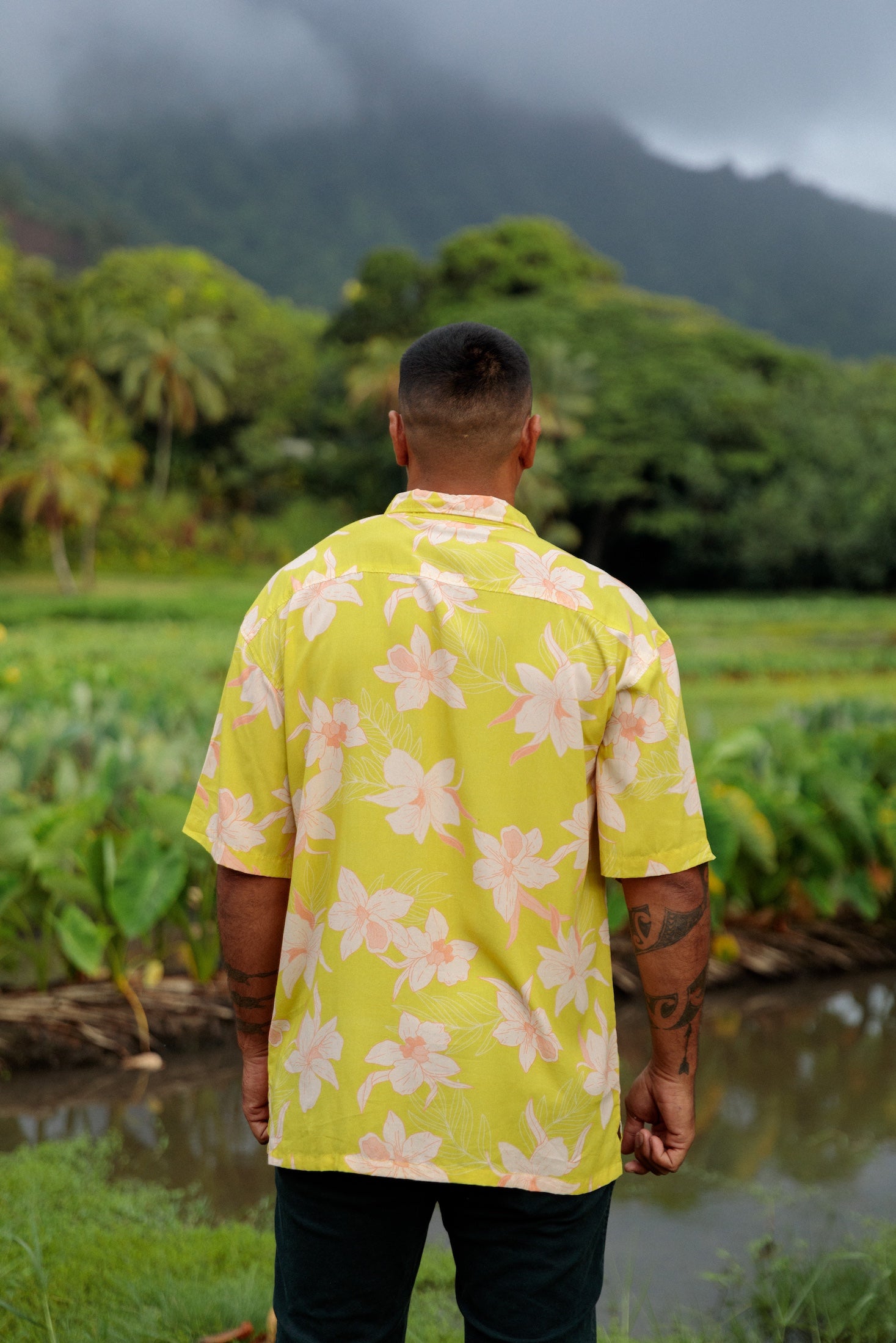 man wearing bright yellow green aloha button up shirt with orchid print