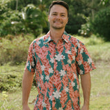 man wearing an aloha button up shirt with red ginger and tiare print