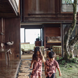 little girl  and her brother wearing matching brown outfits with light pink lei awapuhi print