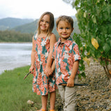little boy wearing an aloha button up shirt with red ginger and tiare print
