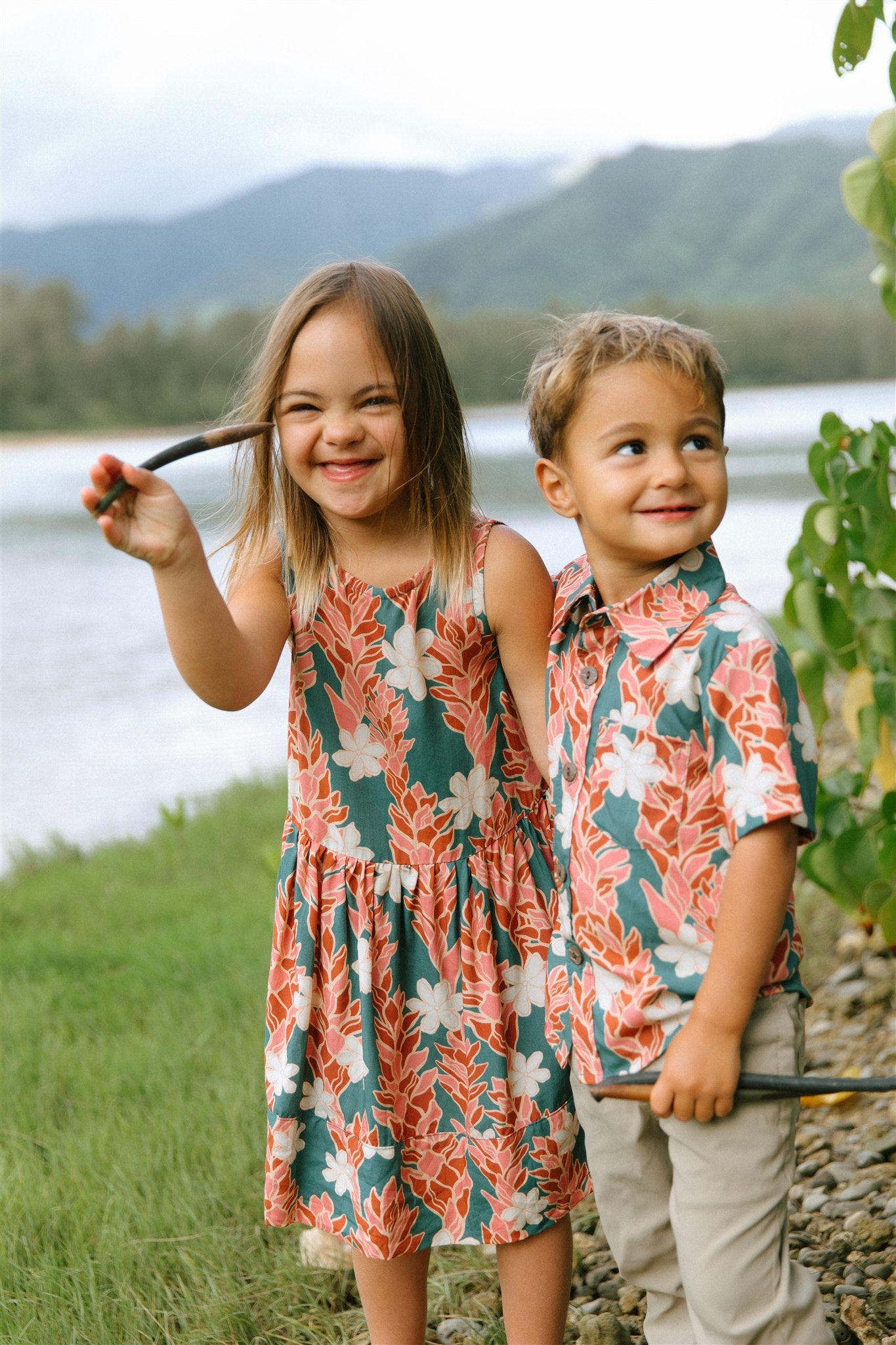 little girl wearing a knee length dress with red ginger and tiare print