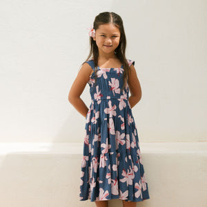little girl wearing a tiered maxi dress in navy and pink hibiscus print.