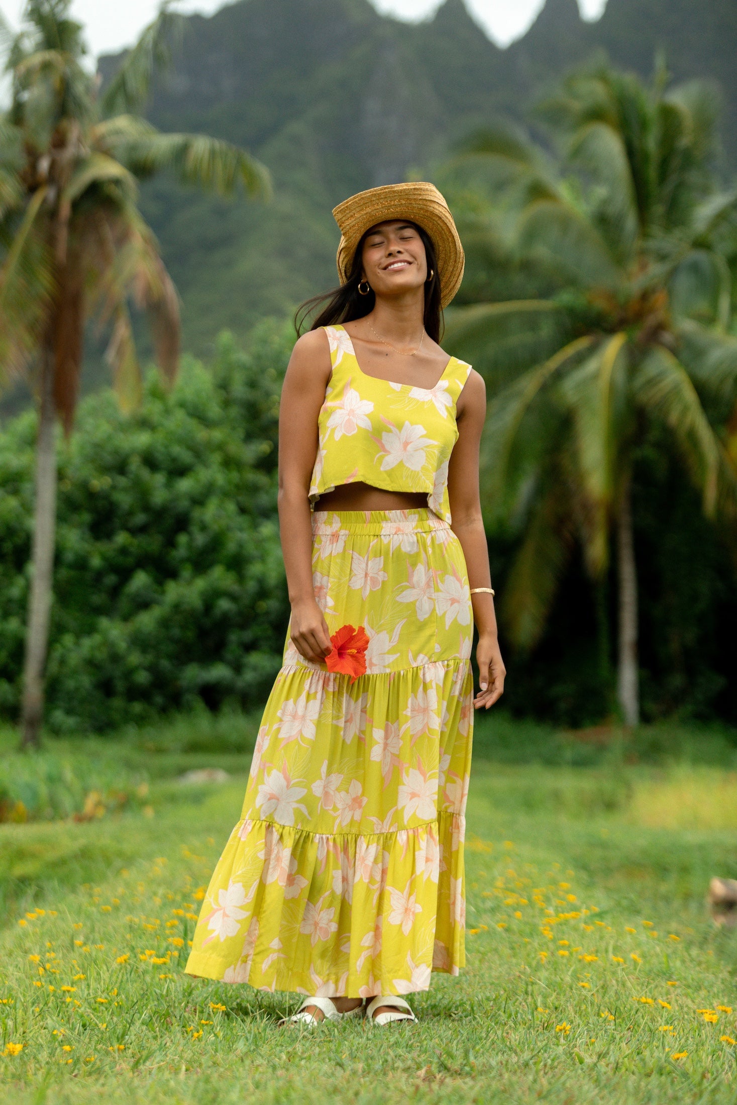 woman wearing a bright green orchid print cropped top with matching maxi skirt
