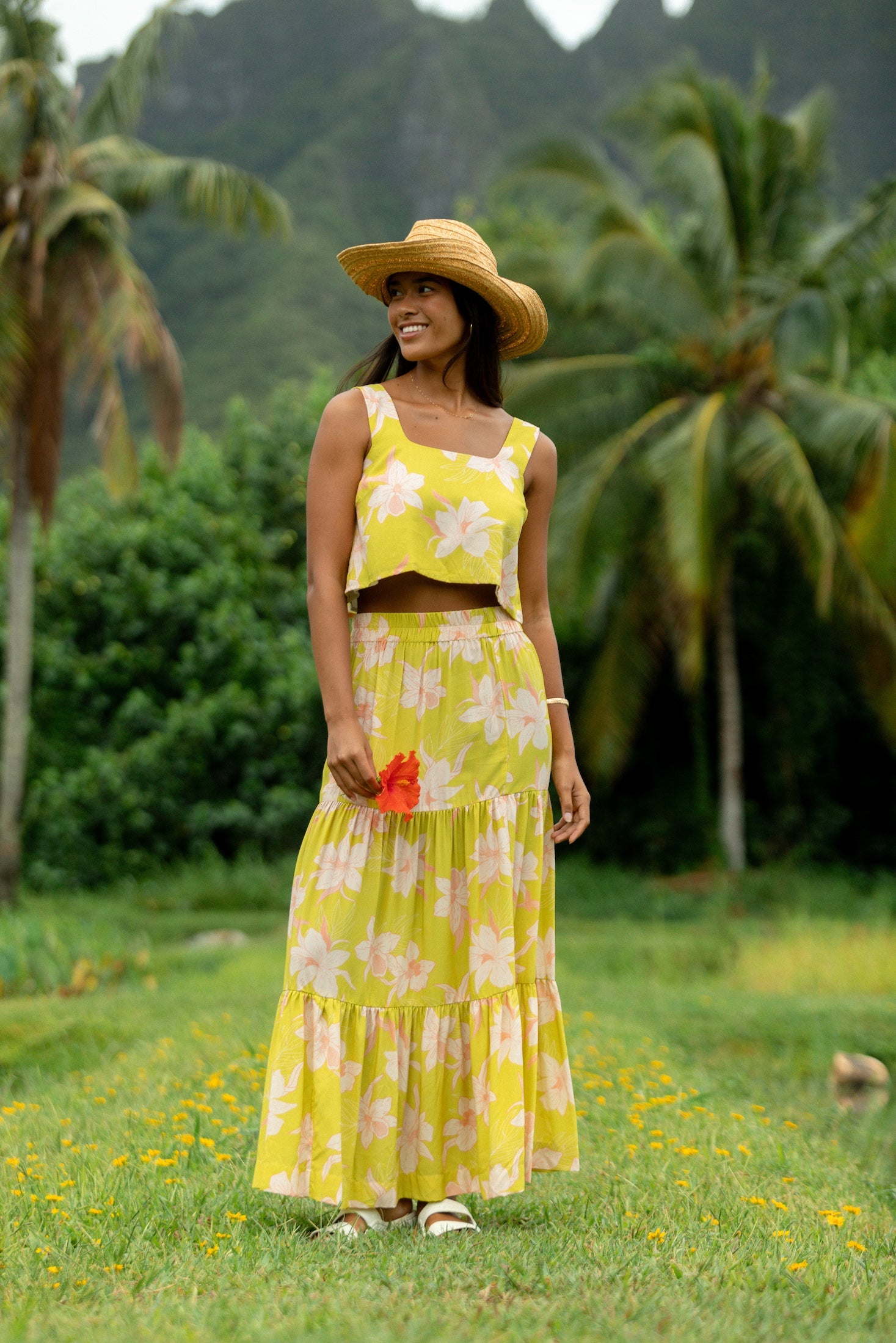 woman wearing a bright green orchid print maxi skirt with matching top