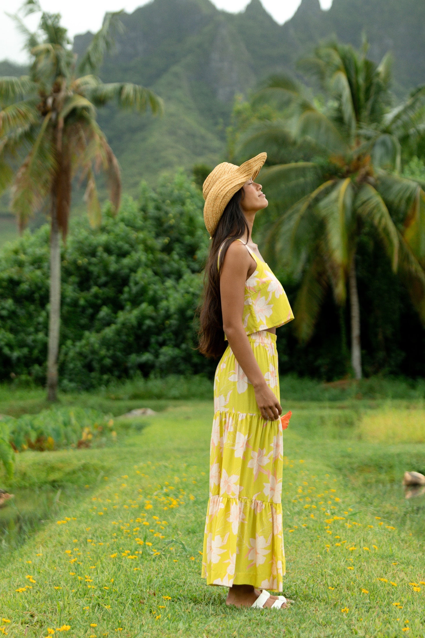 woman wearing a bright green orchid print maxi skirt with matching top