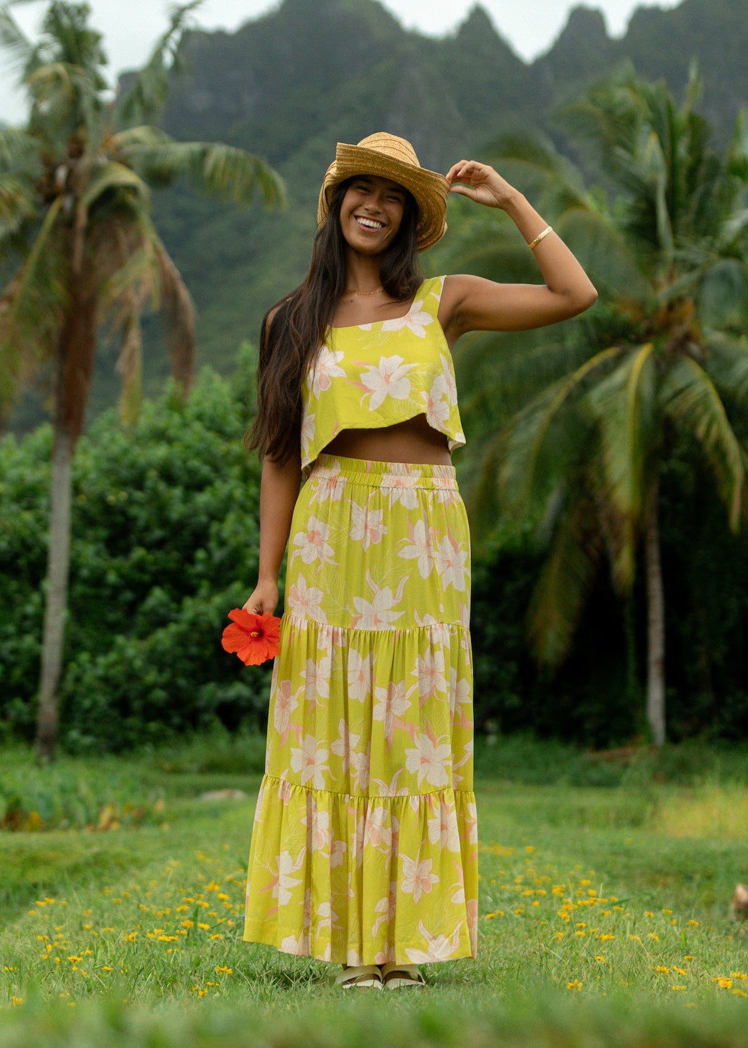 woman wearing a bright green orchid print maxi skirt with matching top
