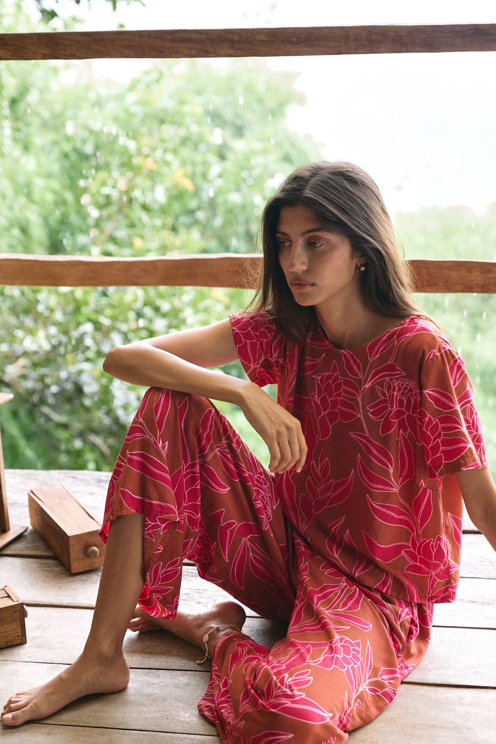 A woman with dark hair wears a YIREH wide legged pant with elastic waistband. It is the Elodi Pant in the Garden 'Awapuhi print.