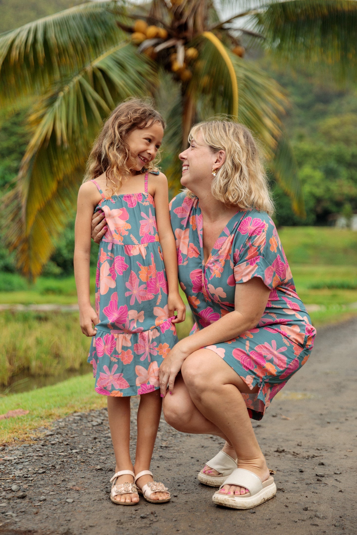 family wearing matching teal aloha wear with floral print