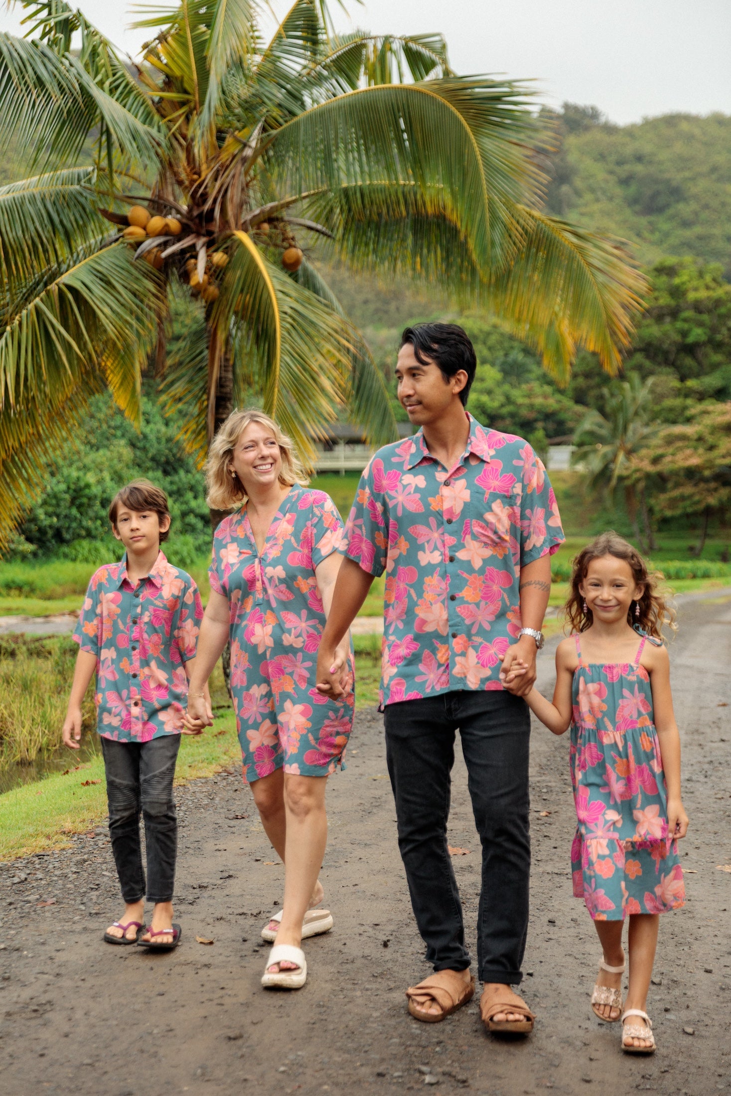 family wearing matching teal aloha wear with floral print