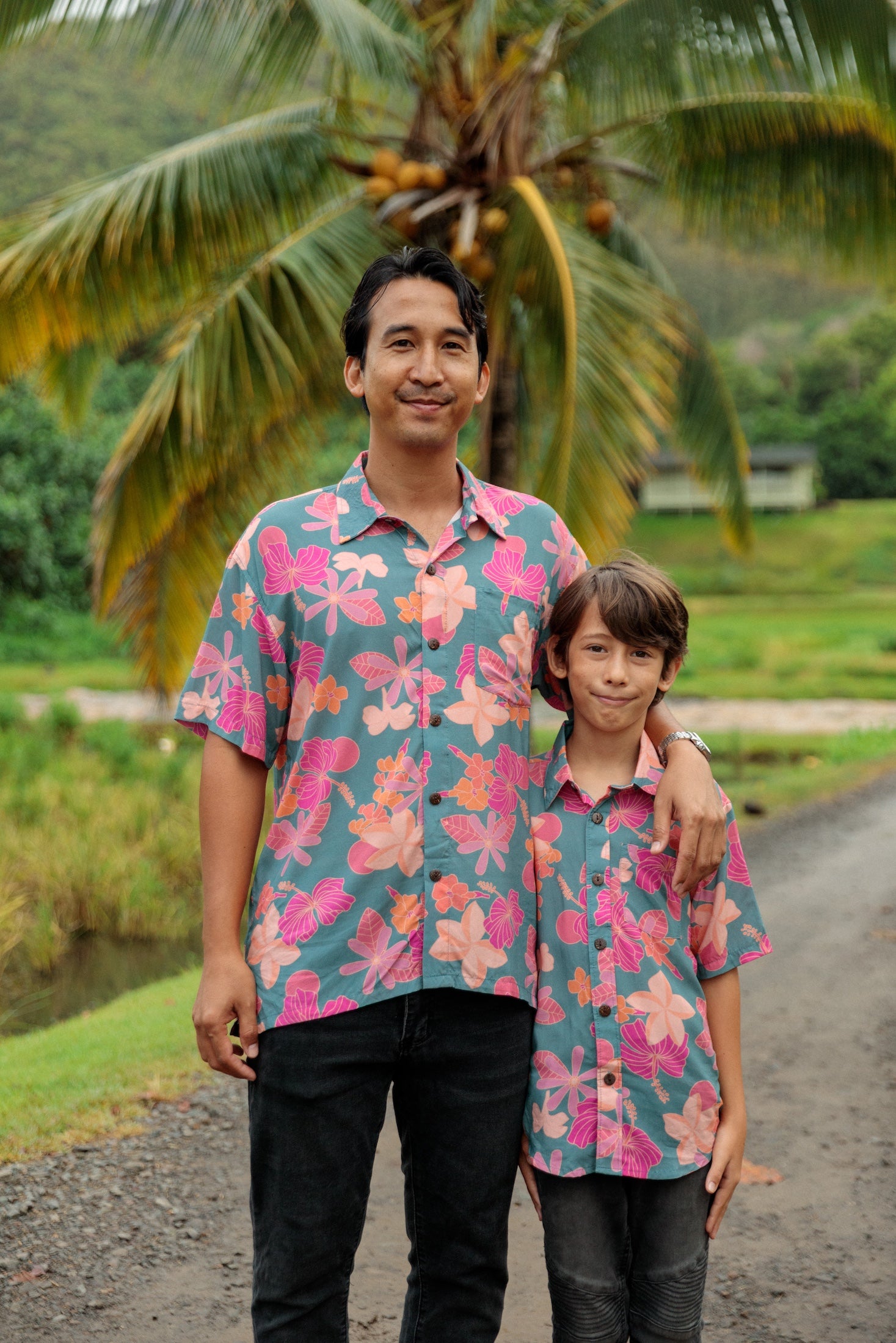 family wearing matching teal aloha wear with floral print