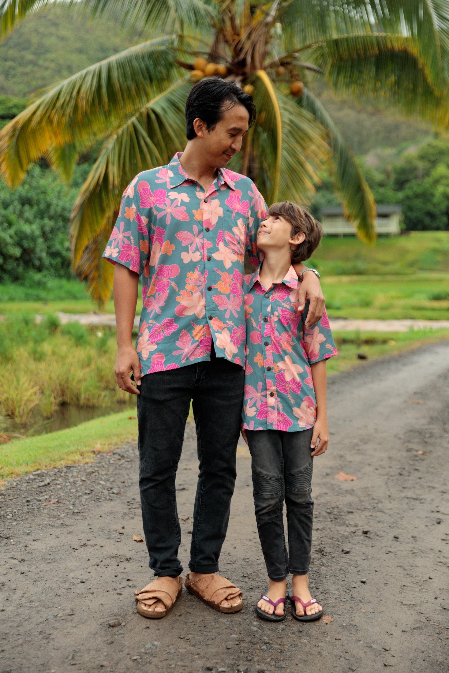 family wearing matching teal aloha wear with floral print