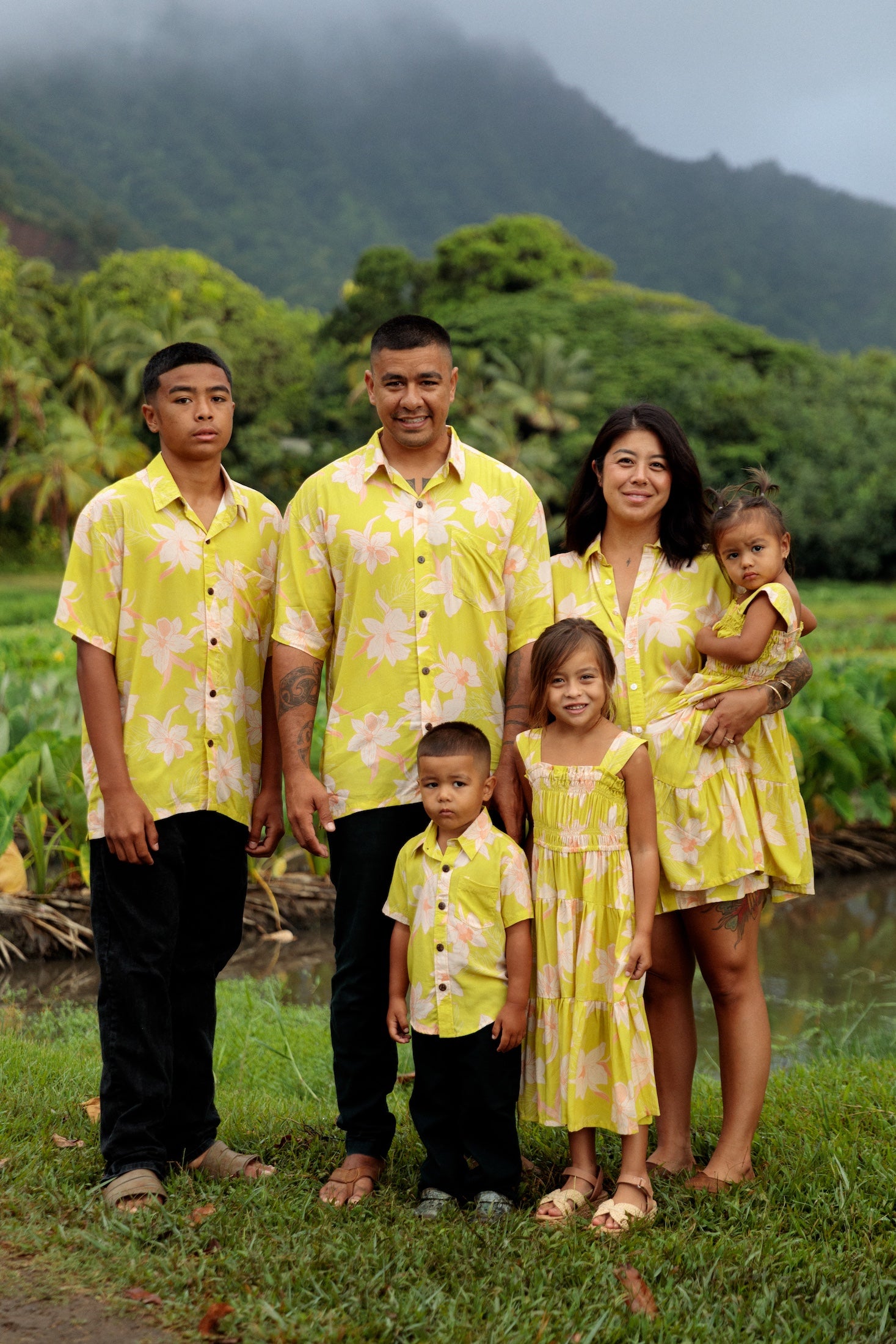 family wearing matching bright green aloha wear with orchid print