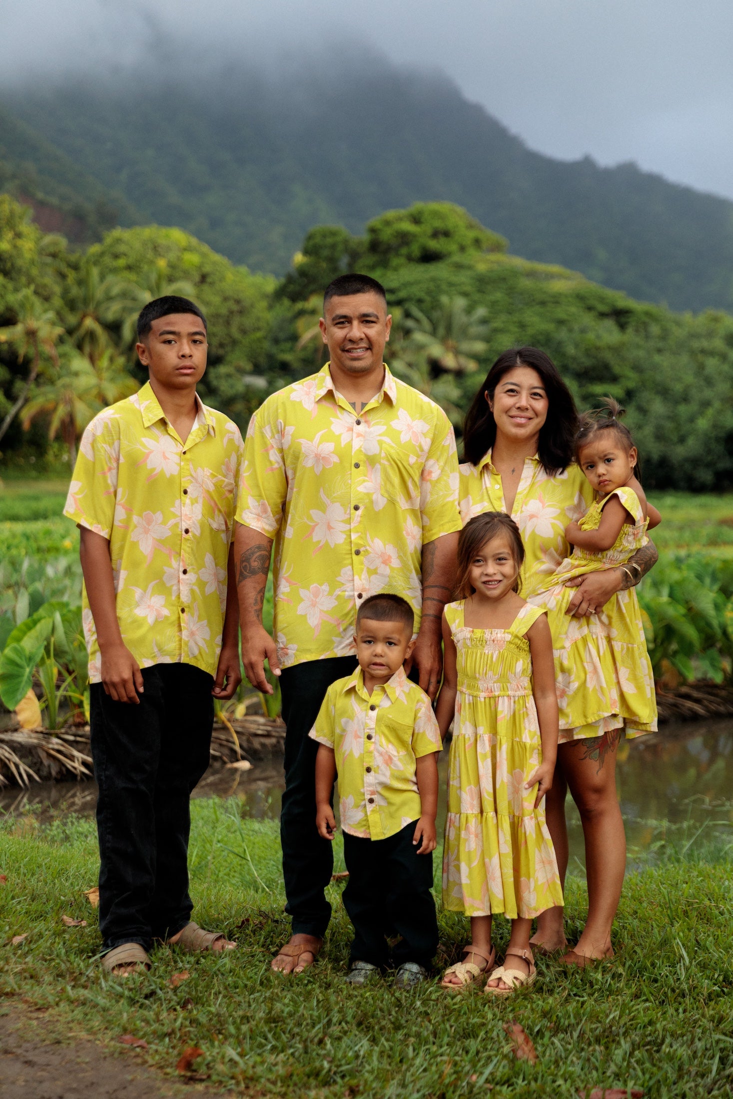 family wearing matching bright green aloha wear with orchid print