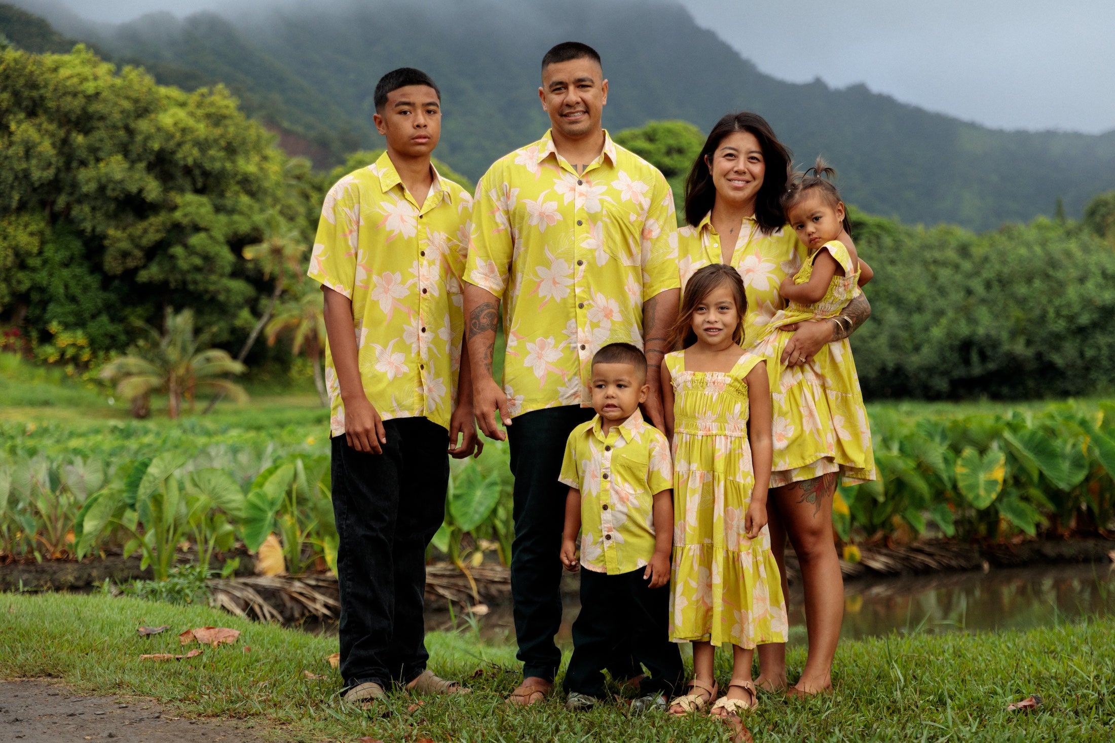 family wearing matching bright green aloha wear with orchid print