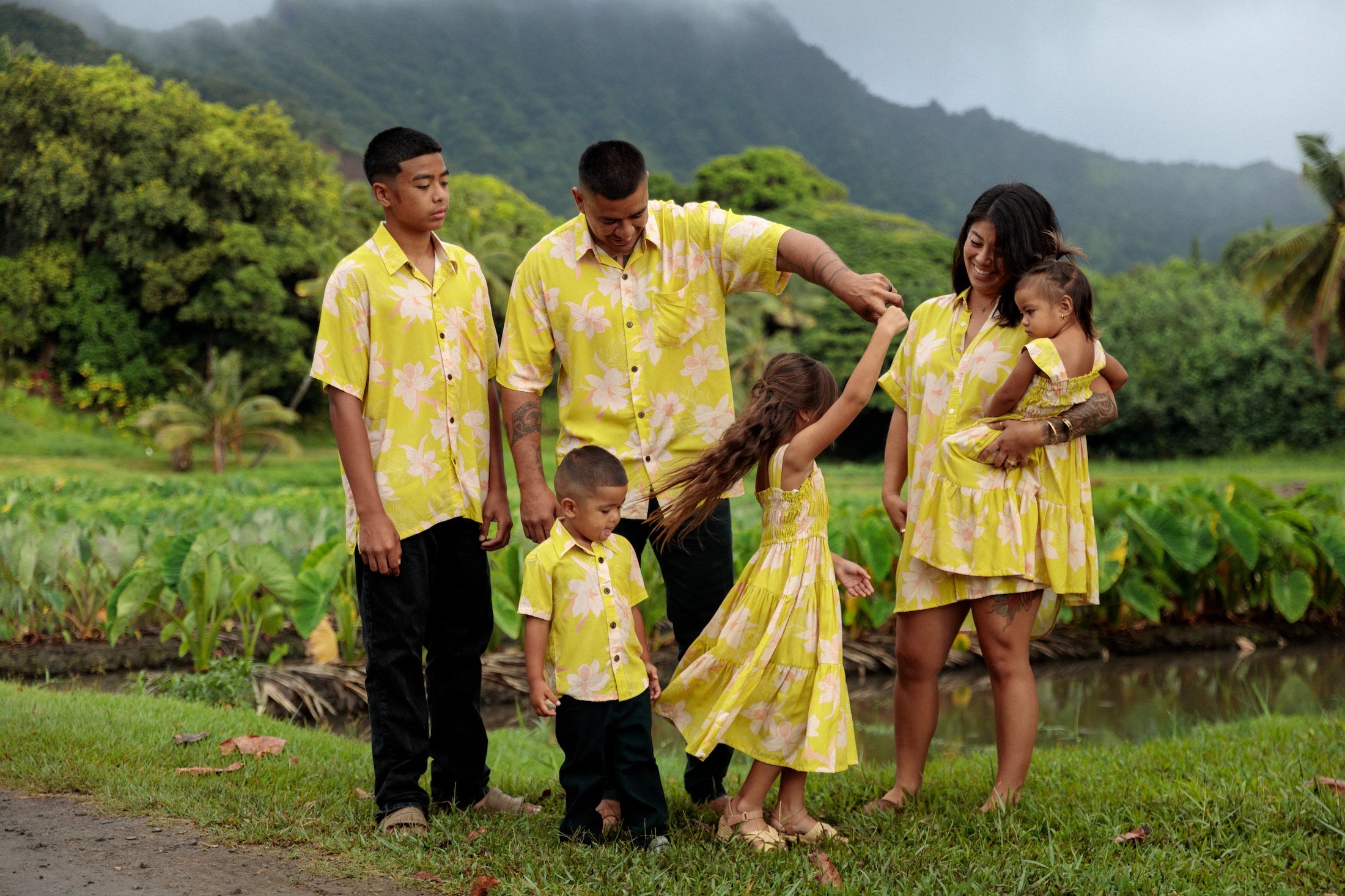 family wearing matching bright green aloha wear with orchid print