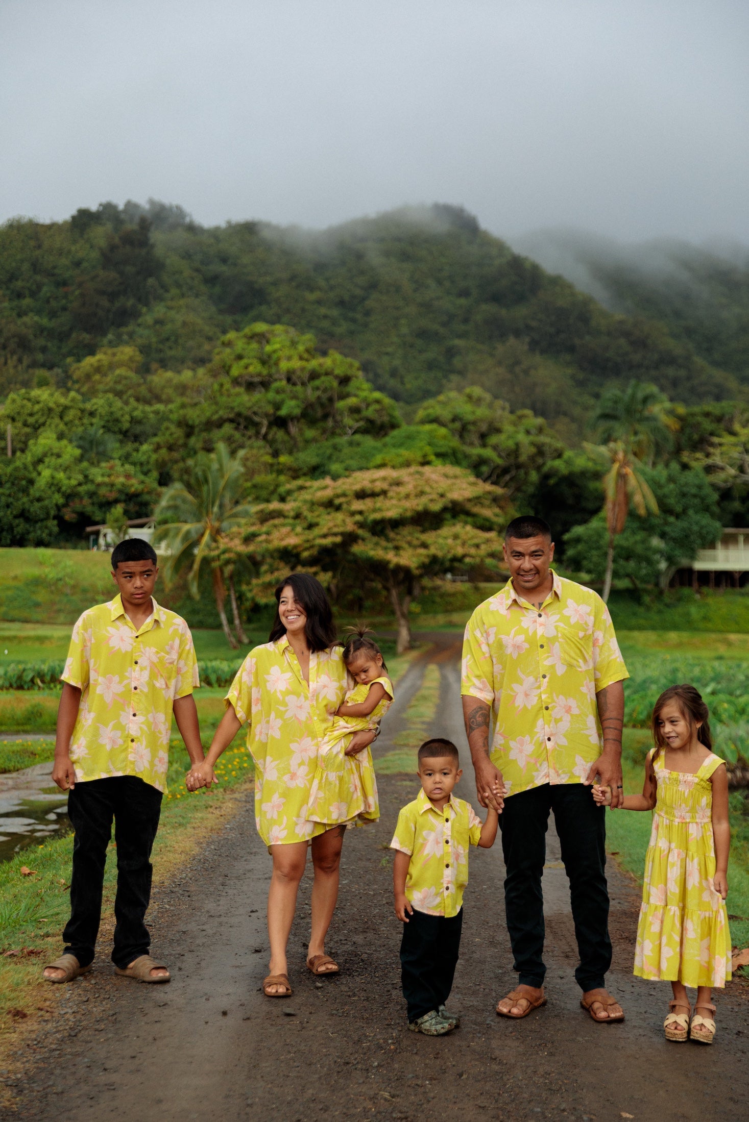 family wearing matching bright green aloha wear with orchid print