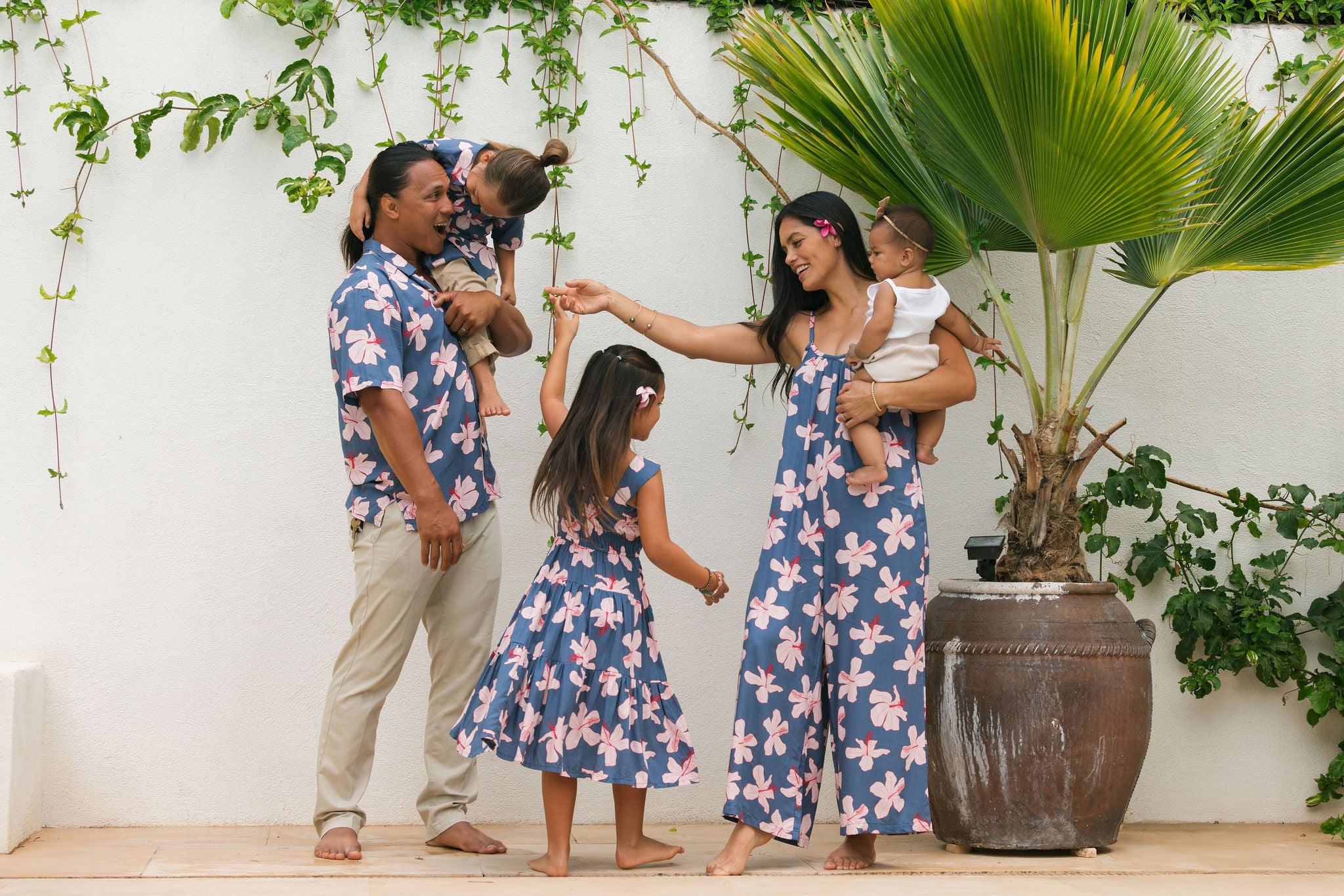 little girl wearing a tiered maxi dress in navy and pink hibiscus print.