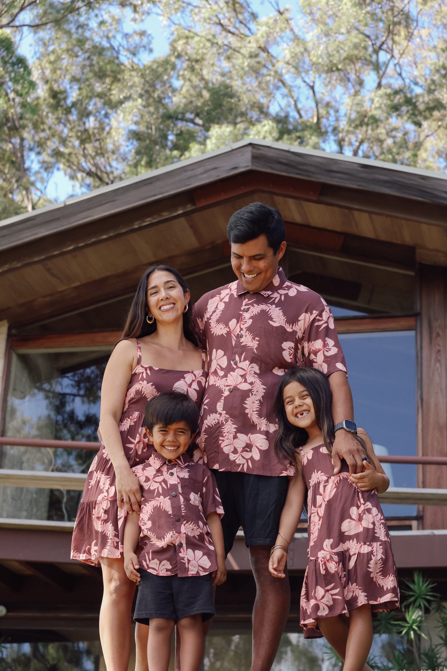 little boy wearing brown aloha shirt with pink lei awapuhi print