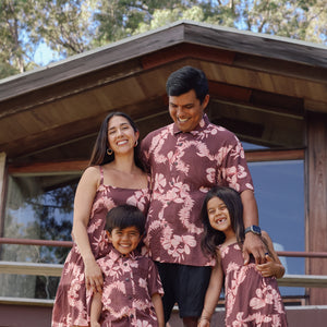 little boy wearing brown aloha shirt with pink lei awapuhi print