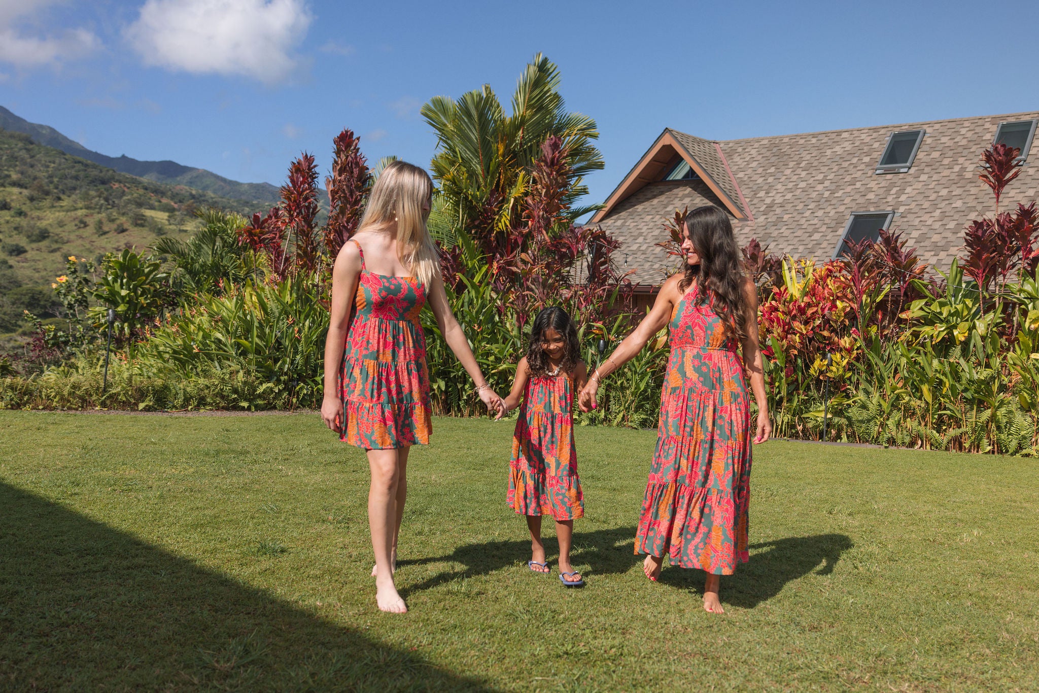 girl with brown hair wearing a colorful dress with tropical lei print