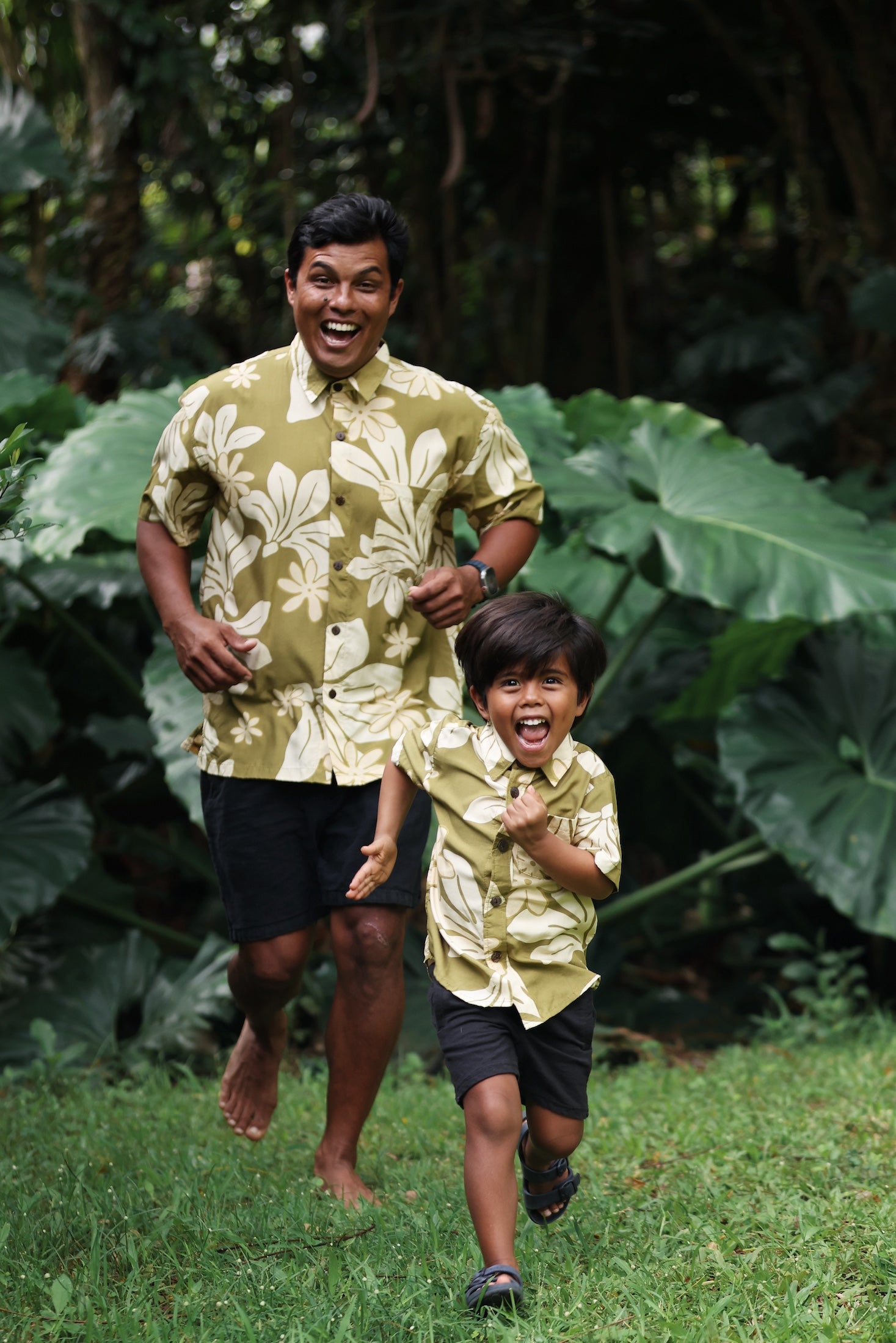 little boy wearing mini aloha button up shirt in green print and naupaka pattern