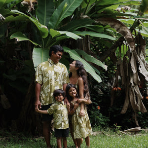family wearing matching aloha wear in green print with naupaka pattern